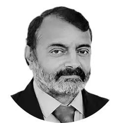 Anil Kumar, Chief Operating Officer, wearing a formal suit and smiling gently in a professional office setting with a calm and welcoming atmosphere